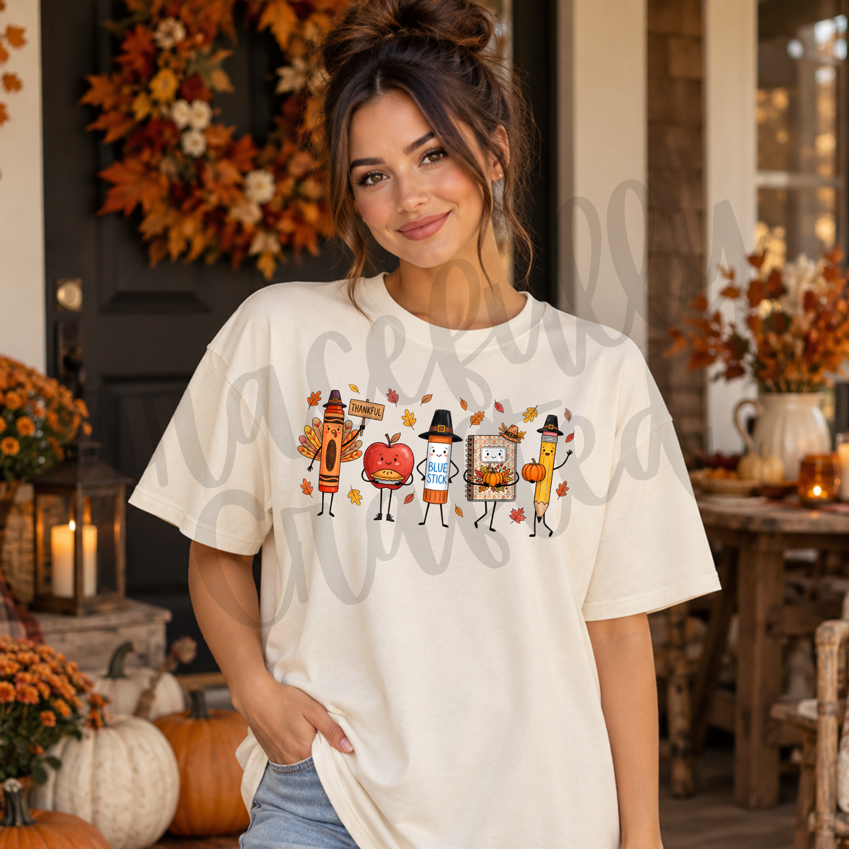 A woman wearing a cream-colored graphic t-shirt with a cartoon Thanksgiving table design
