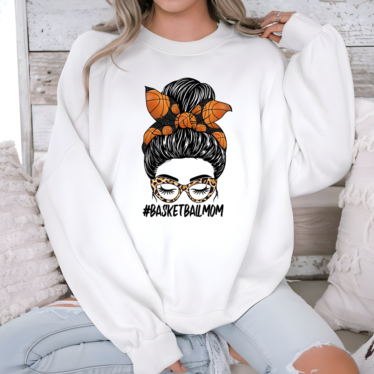 White shirt featuring a basketball-themed mama design with an orange bow and black lettering.