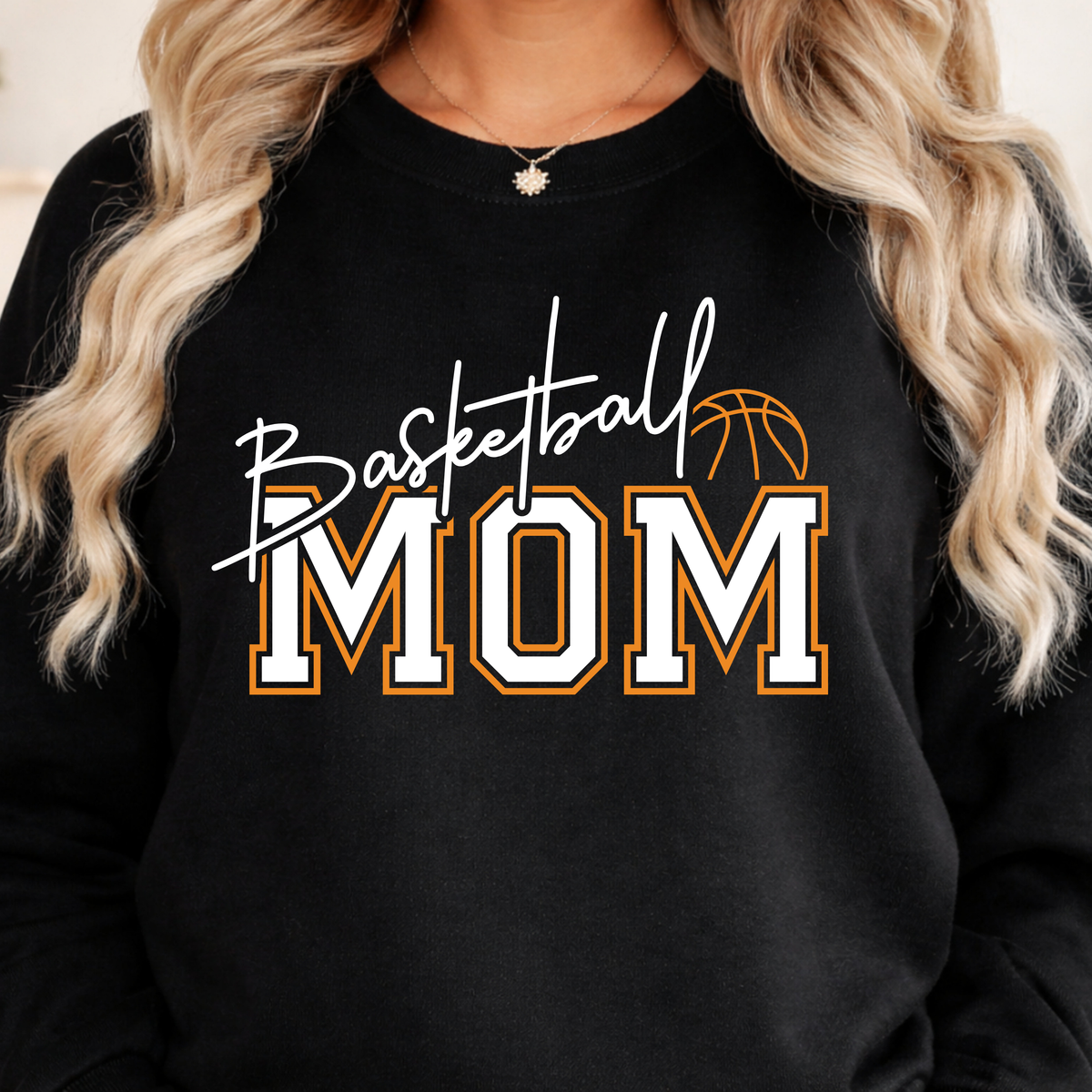 Black shirt featuring Basketball Mom lettering in white and orange with a basketball illustration.
