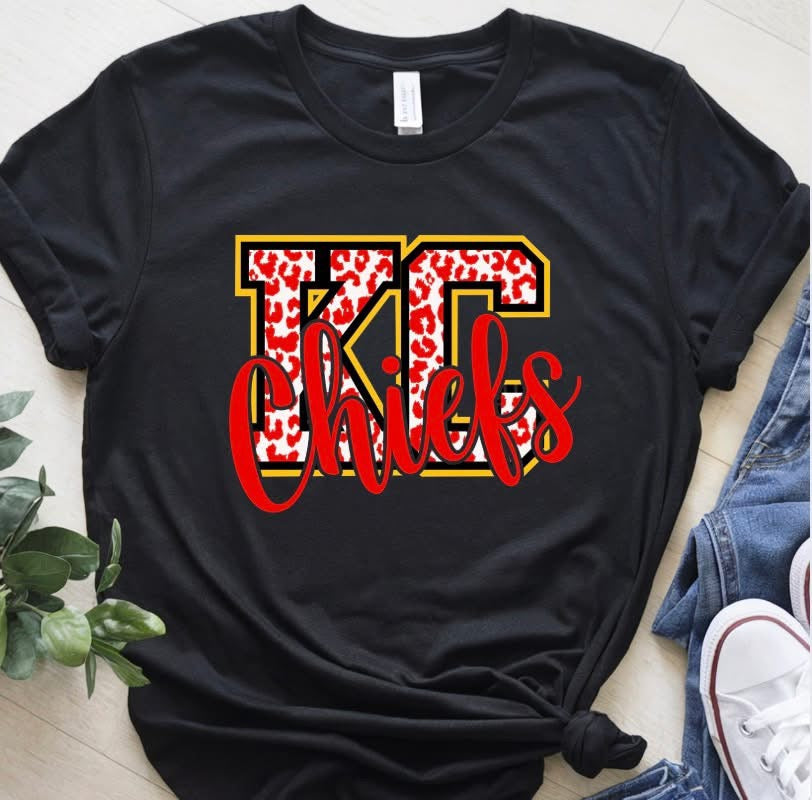 Kansas City Chiefs graphic featuring oversized KC letters filled with a red and white leopard print, outlined in black and gold, with red Chiefs script layered across the front.