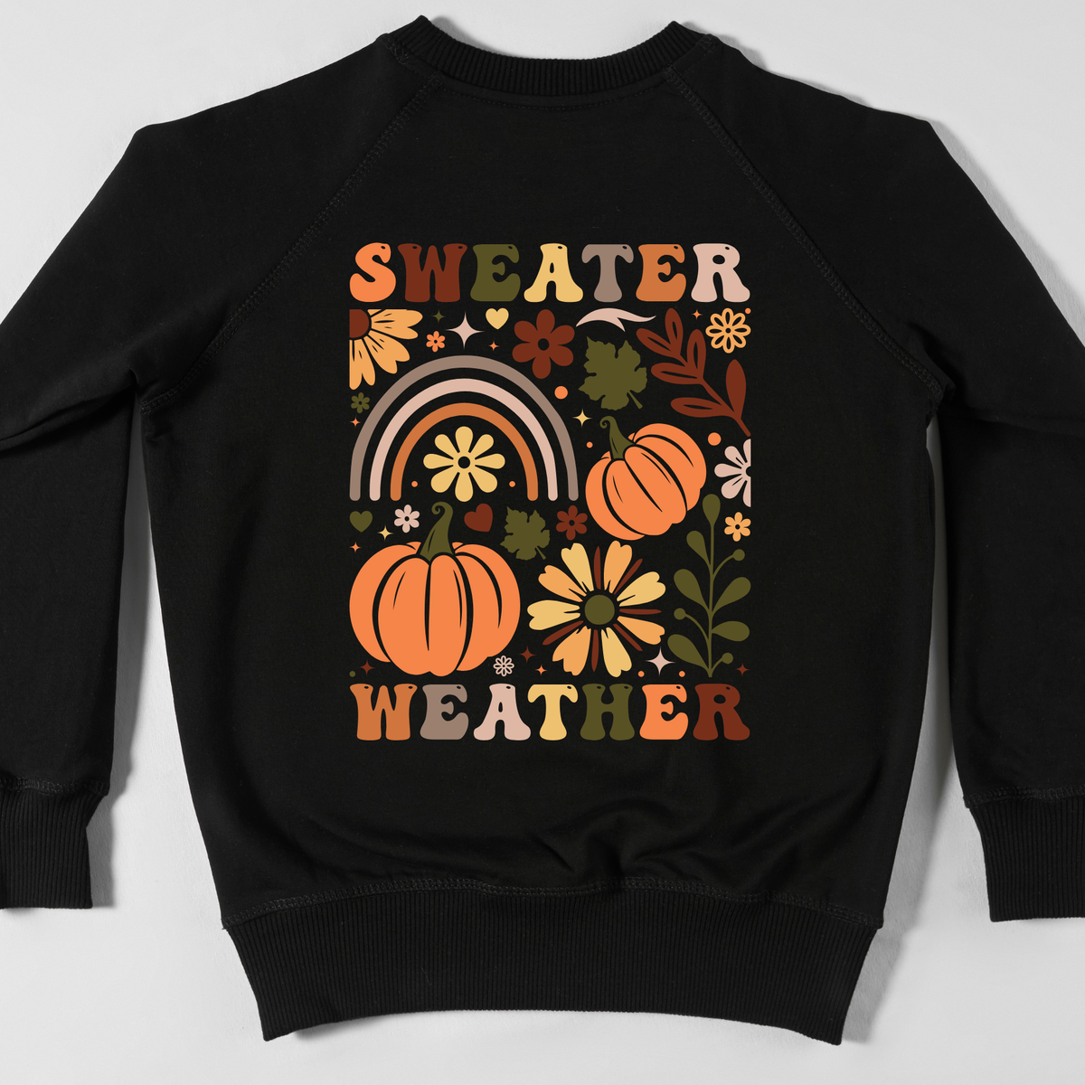 Sweater Weather lettering with orange pumpkins, sunflowers, and colorful autumn decorations.
