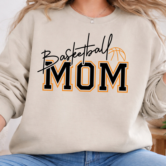 Sand-colored shirt featuring Basketball Mom lettering in black and orange with a basketball illustration.