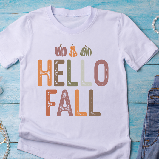 A white short-sleeve t-shirt  featuring a distressed 'HELLO FALL' graphic with small pumpkin illustrations above the text.