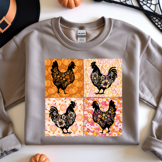 A sand crewneck sweatshirt featuring a four-panel graphic print of black rooster silhouettes decorated with intricate floral and geometric patterns on orange, pink, and cream backgrounds.