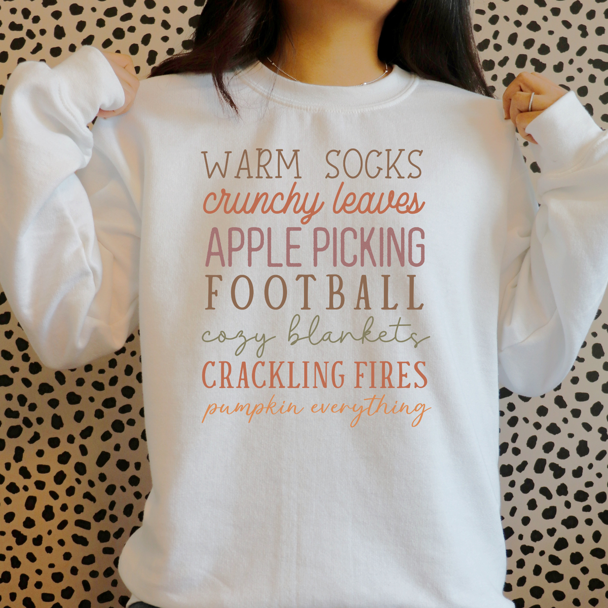 Stacked fall sayings including Warm Socks, Crunchy Leaves, Apple Picking, Football and Crackling Fires in muted autumn colors.