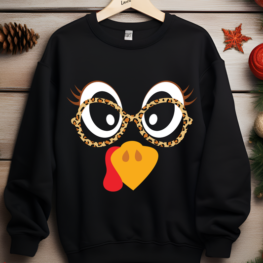 Playful cartoon turkey face with oversized eyes, long eyelashes, leopard print glasses, and an orange beak.